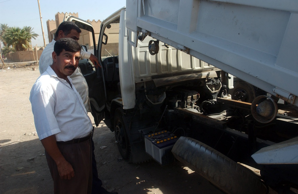 Soldiers Deliver Garbage Trucks to Al Mansour