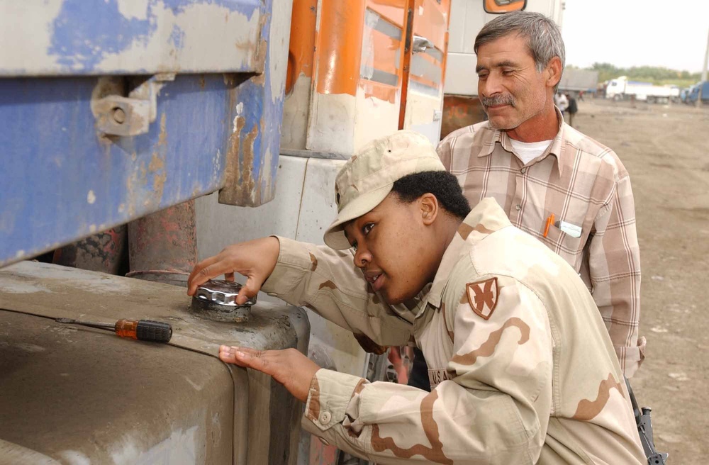Spc. Davis checks for fuel in an Iraqi truck