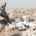 Trash litters the ground where an Oregon Guardsman walks