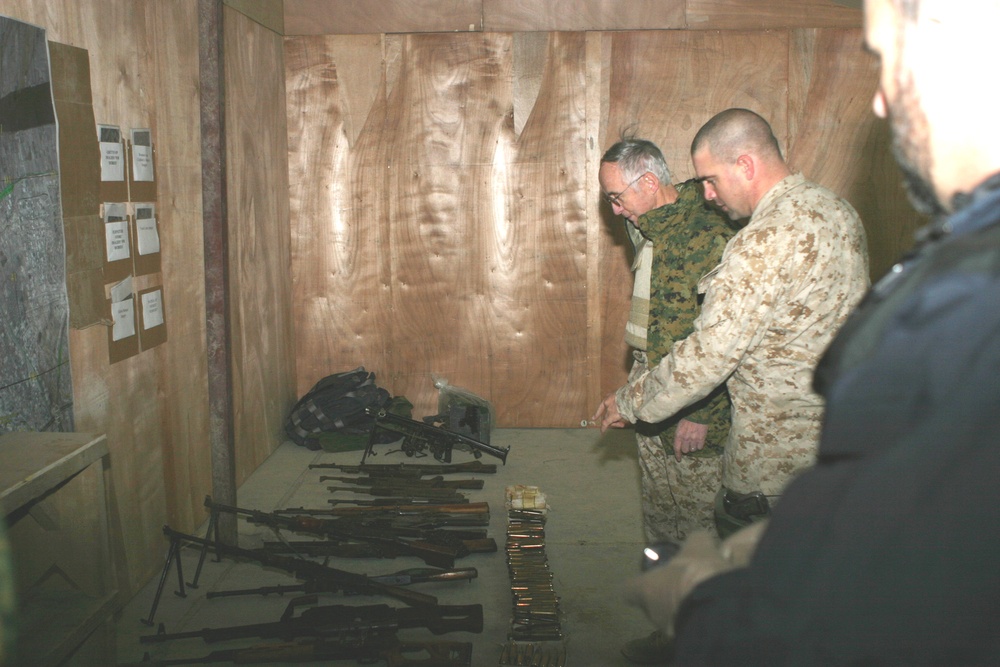 The Secretary of the Navy looks at a weapons cache