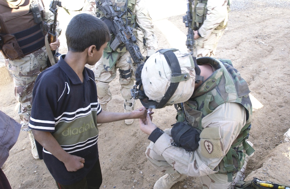 Spc David Maples administers first aid to a local