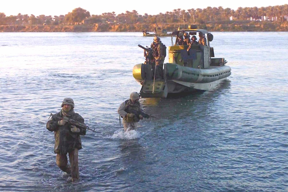 Marines wade through the waters of the Euphrates River
