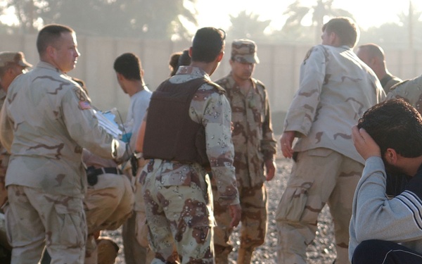 An ING looks on as his comrades are treated