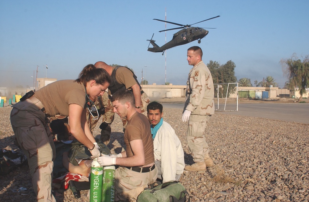Soldiers prepare a wounded ING soldier for medivac