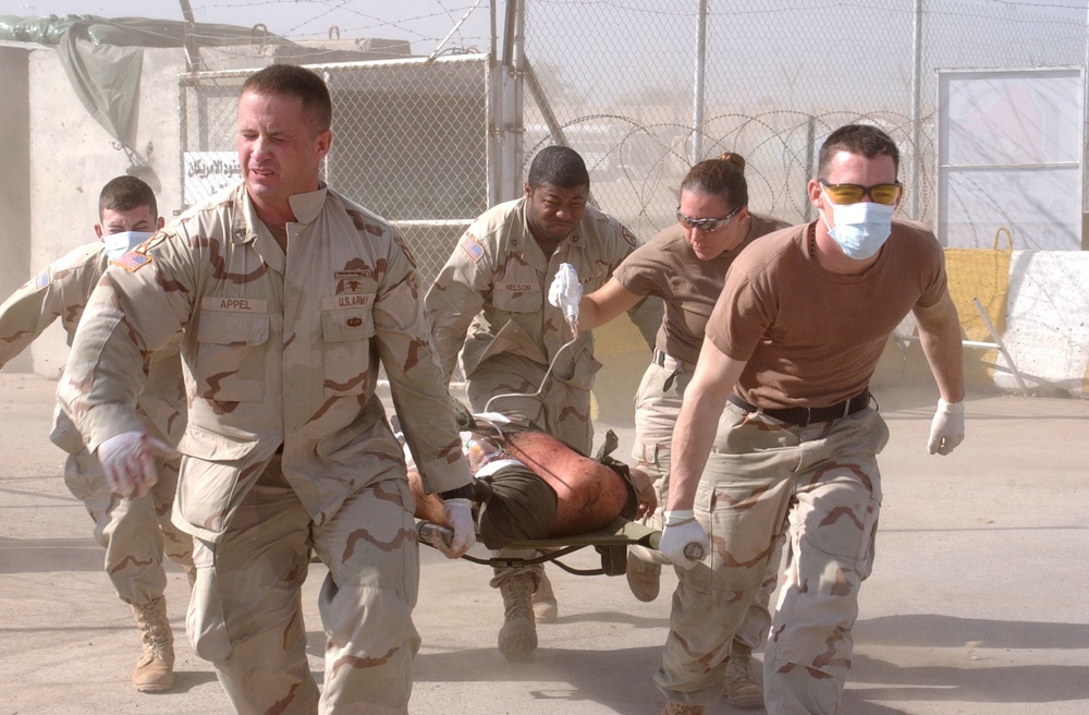 Soldiers carry an injured Iraqi to a medivac