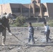 Children and Soldiers clean a field in eastern Baghdad
