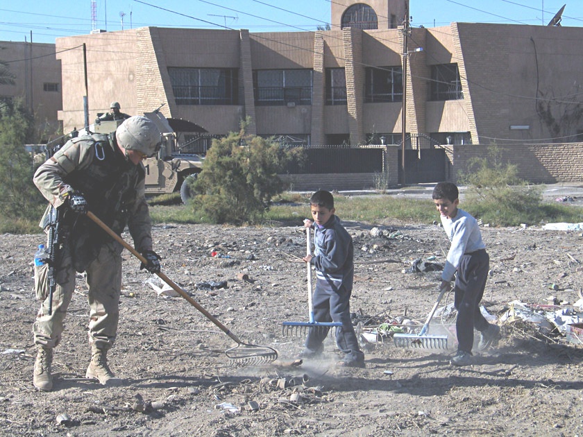 Children and Soldiers clean a field in eastern Baghdad