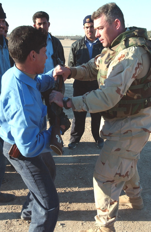 Sgt. Dan MacDonald  instructs an Iraqi police patrolman