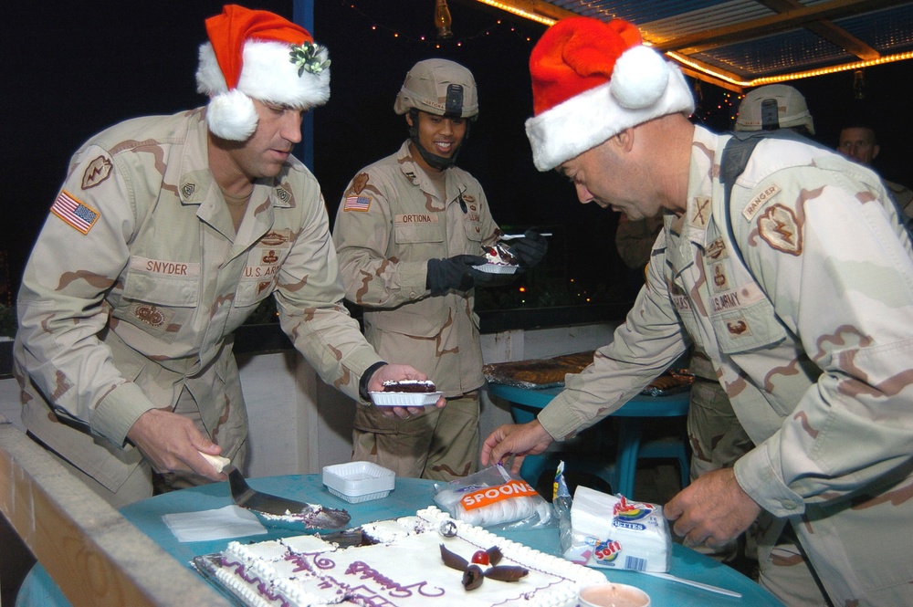 Soldiers grab a piece of cake after the holiday card lighting ce