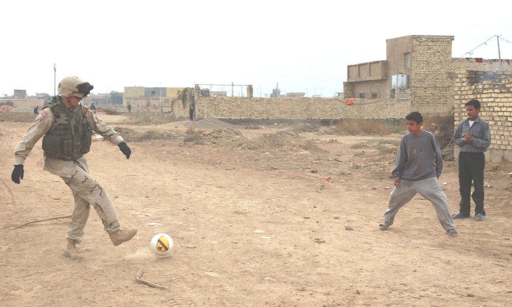 Capt. Coley Tyler plays soccer with children