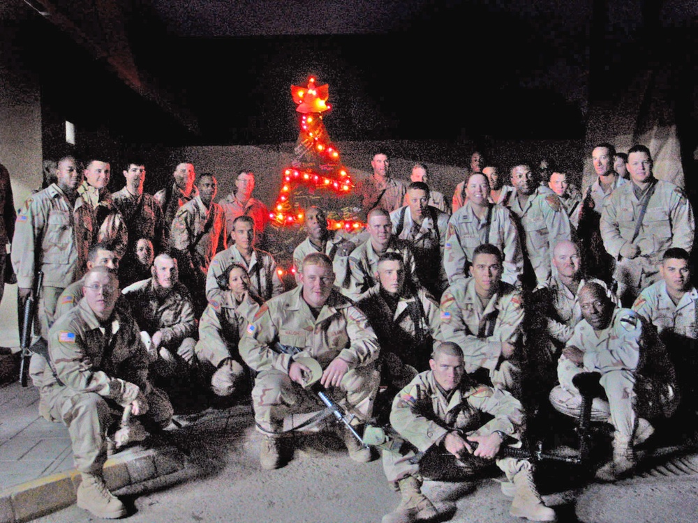 Soldiers pose in front of the battalions motor pool Xmas tree