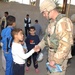 PFC Bailey hands activity books to local children