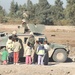 Soldiers entertain some kids near a construction site