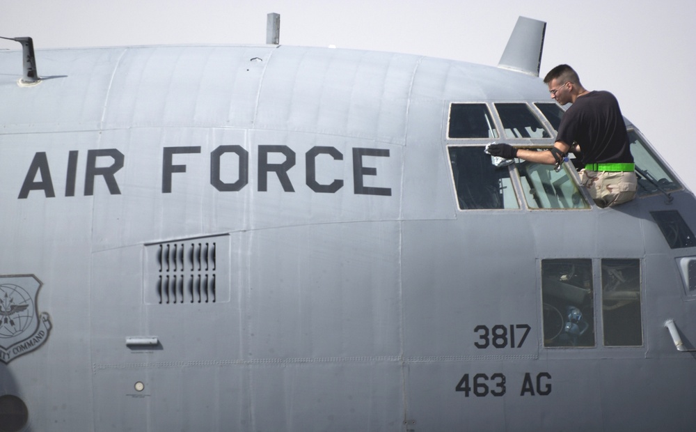 A crew chief cleans the windows of his C-130 aircraft