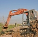 An engineer uses an excavator to bury a drainage pipe