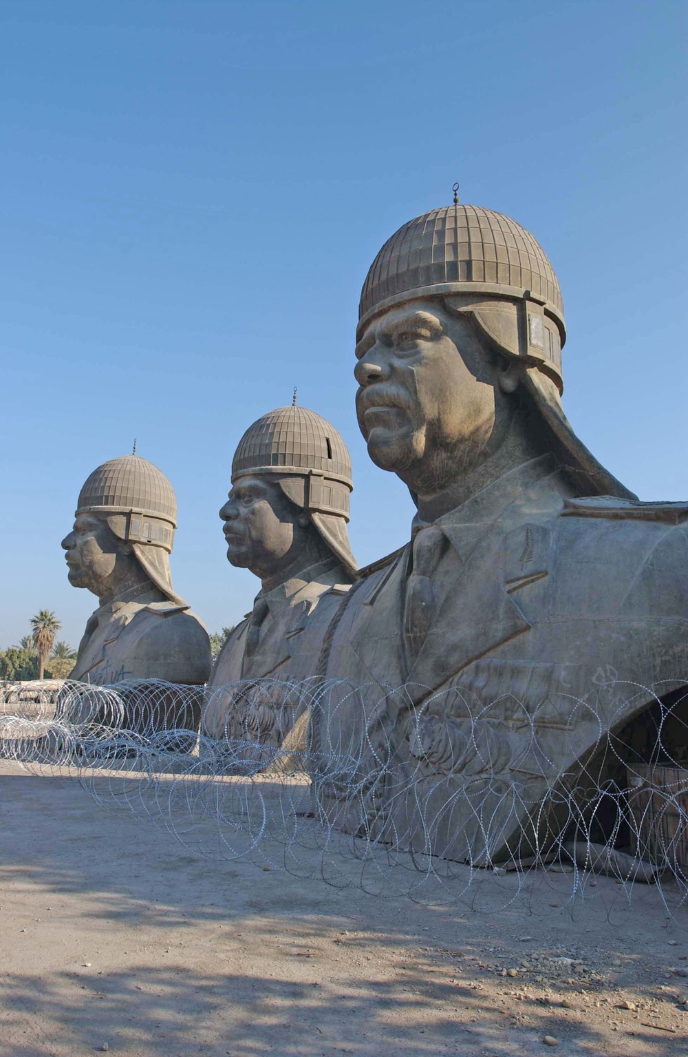 Three statues of Saddam Hussein