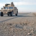 An IED crater lies on the shoulder of a road