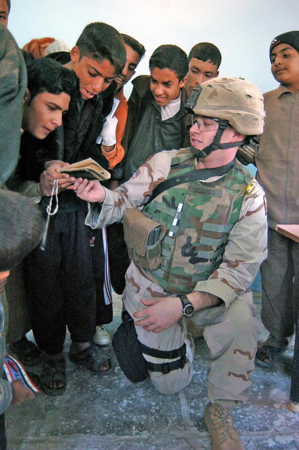 Sgt. Scaggs shows Iraqi children a photograph of his wife and ki