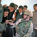 Sgt. Scaggs shows Iraqi children a photograph of his wife and ki