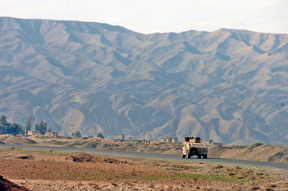 A HMMWV drives toward a small village near the Tigris River