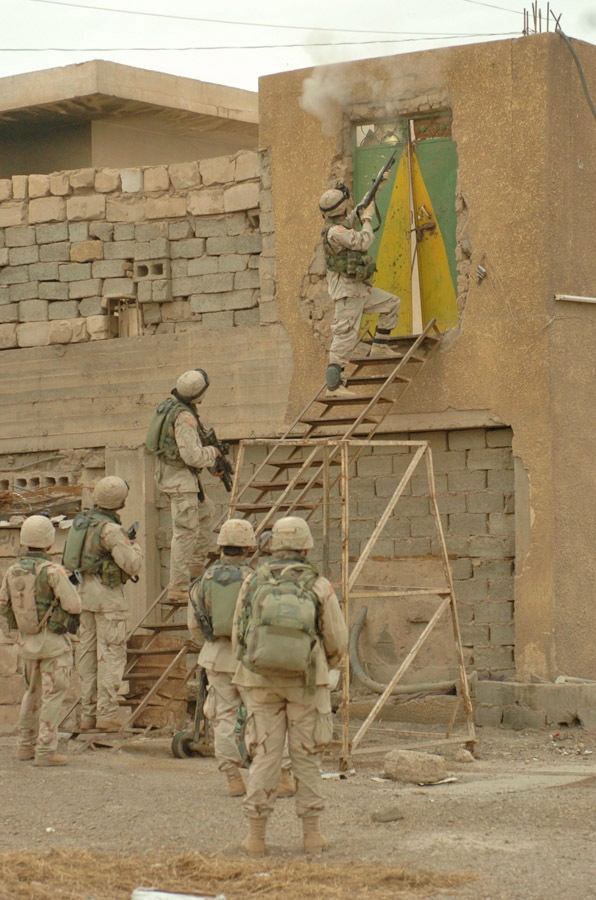 SPC Steven K. Menard shoots the lock off a door