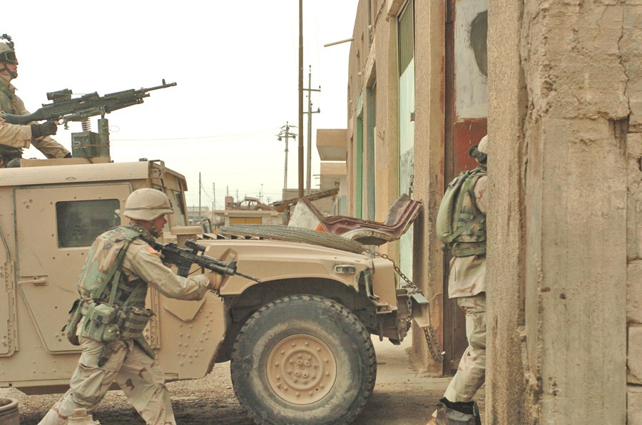 SPC Stephen Lewis charges into a building