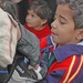 A child receives an armful of clothing and shoes