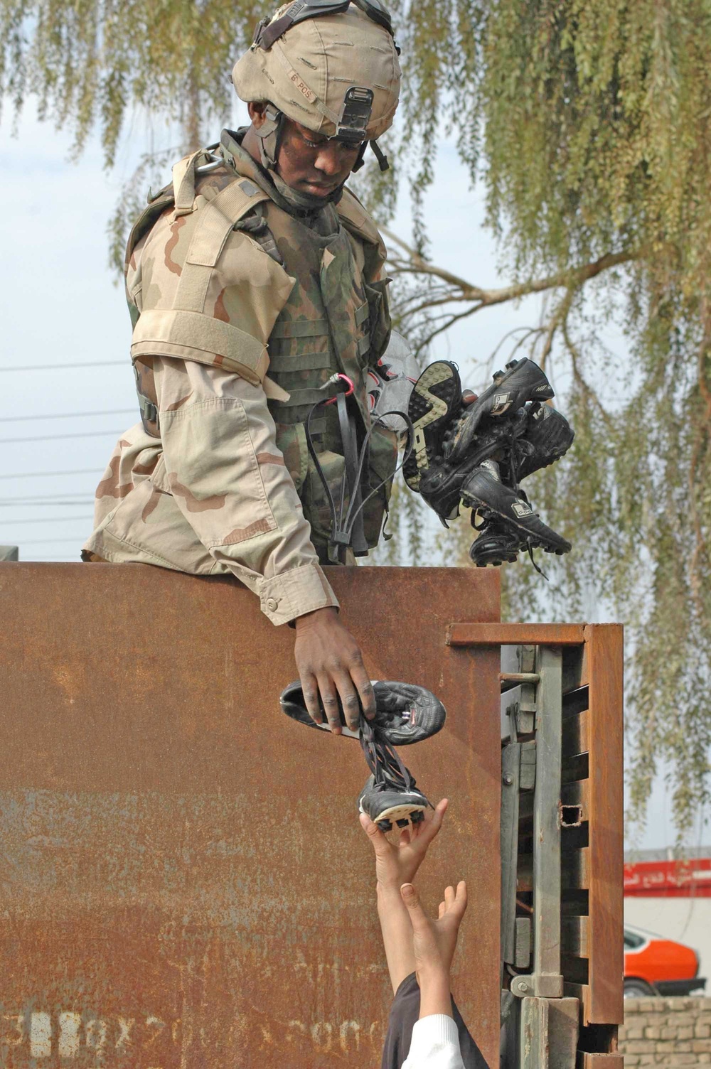 Spc. Vester Smith  lowers a pair of soccer shoes to some wanting