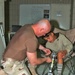 Capt. Steve Lindsley makes adjustments to the prosthetic leg
