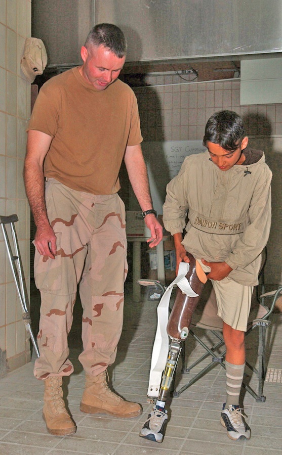 Sgt. Chris Cummings helps a young Iraqi boy