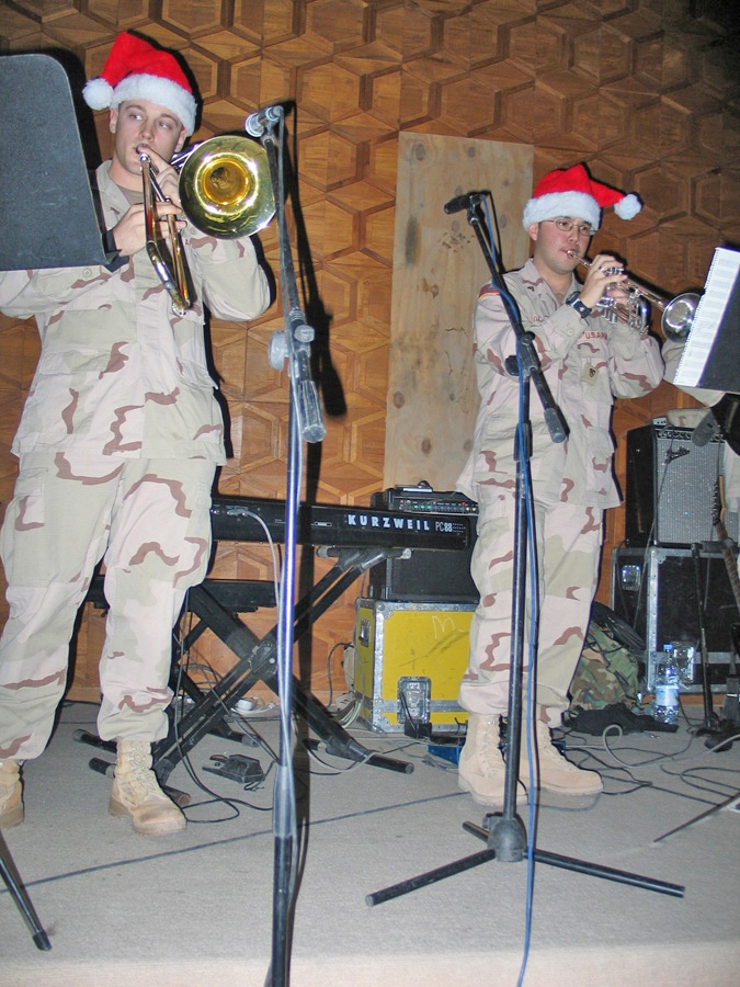 Soldiers don Santa Claus hats as they provide accompaniment