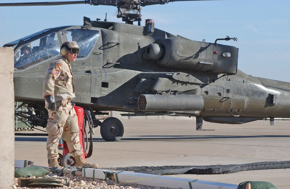 Spc. Geoffrey Ives stands ready at a fire extinguisher.