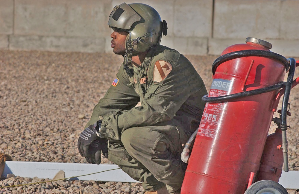 Spc. West crouches down as his counterpart works