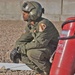 Spc. West crouches down as his counterpart works