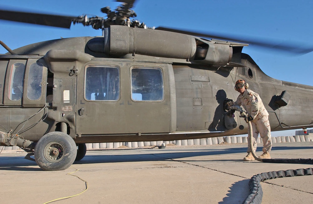 Pfc Rasheen Davis tops off a Black Hawk Helicopter.