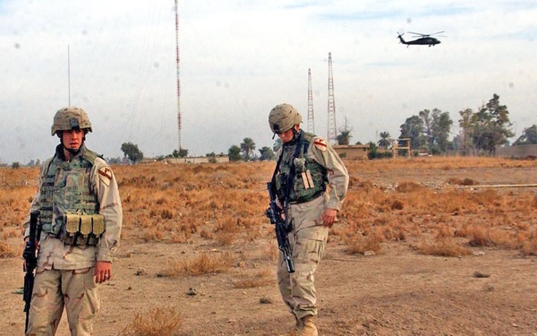 Soldiers inspect a cavity that was dug into the ground