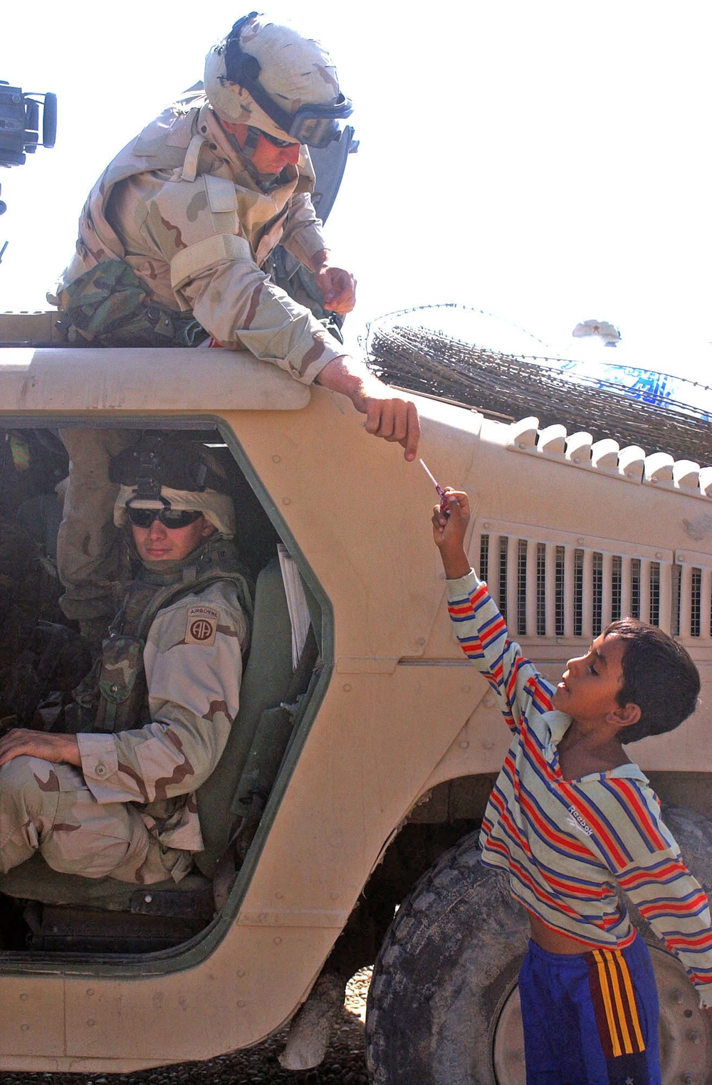 Soldiers hand out candy to Iraqi children near Baghdad