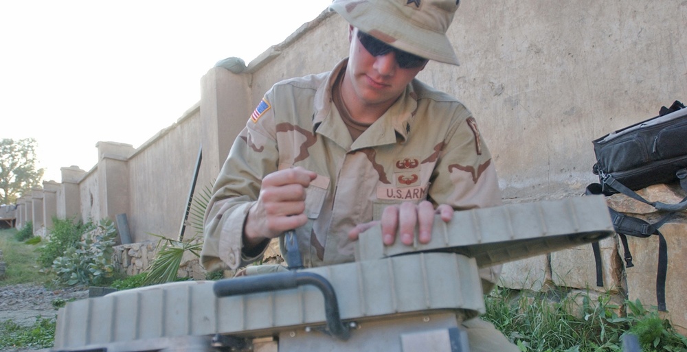 Sgt. Harding replaces the battery in a remote controlled robot