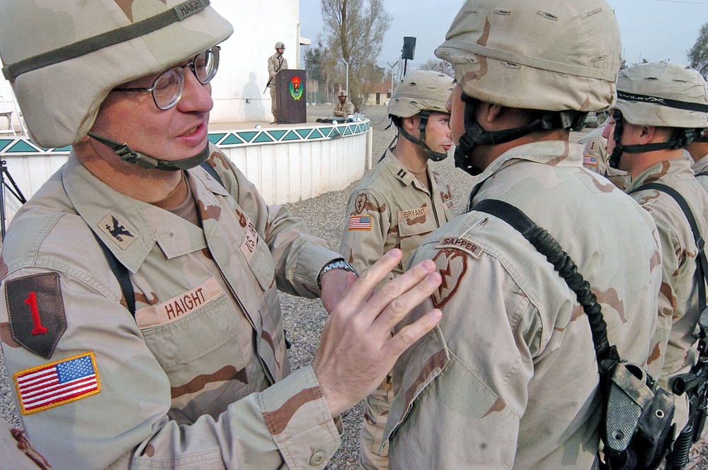 Col. William Haight places a Sapper tab on the shoulder