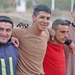 John Salas smiles for a photo with some Iraqi Police soccer play