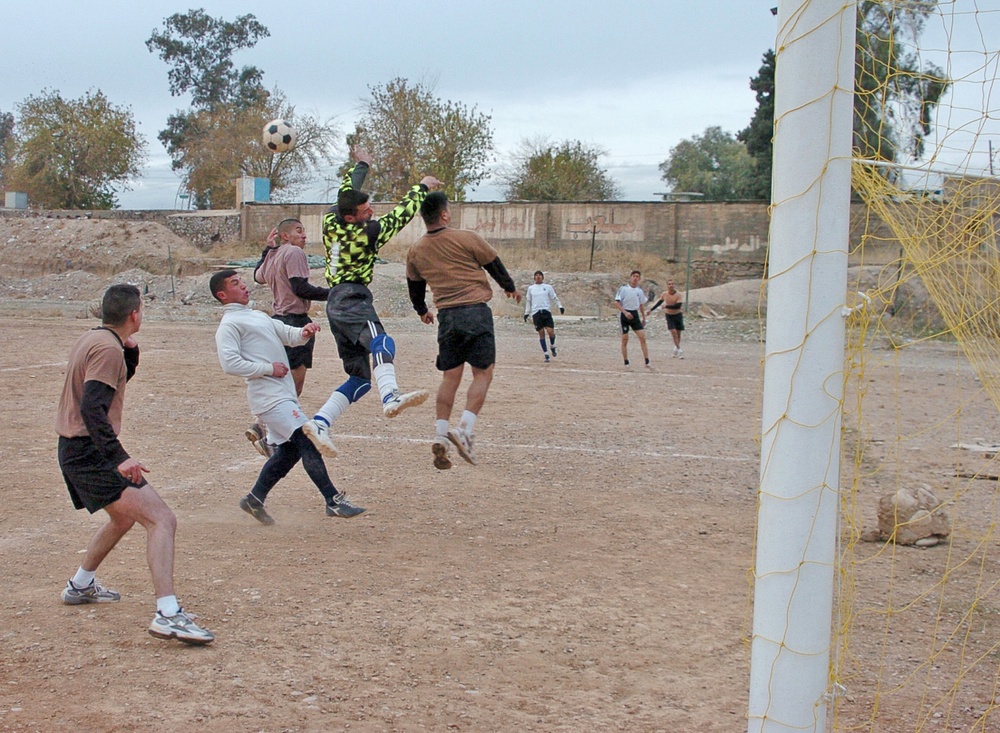 Bravo Co. and Iraqi Police players battle for a soccer ball