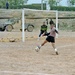 William Reynoso kicks a soccer ball toward the Iraqi Police goal