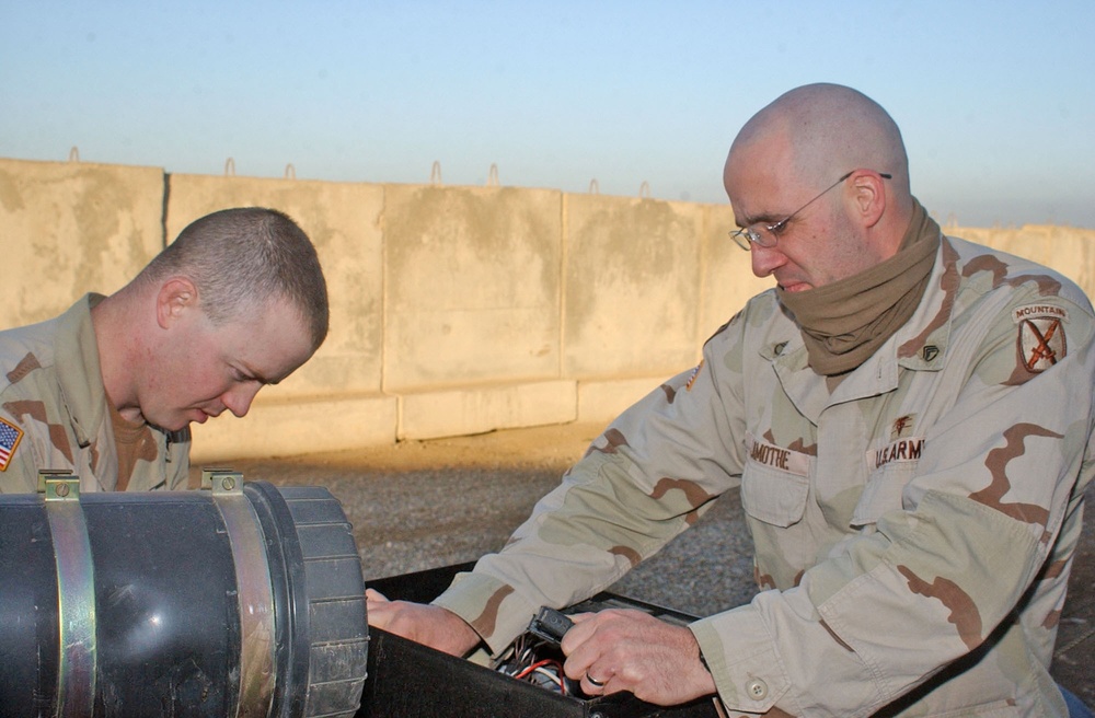 Sgt Shultz and SSgt. Lamothe fix a generator outside