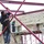 A local man welds a frame that will support the roof