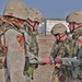 Spc. Anthony Page is handed his reenlistment certificate