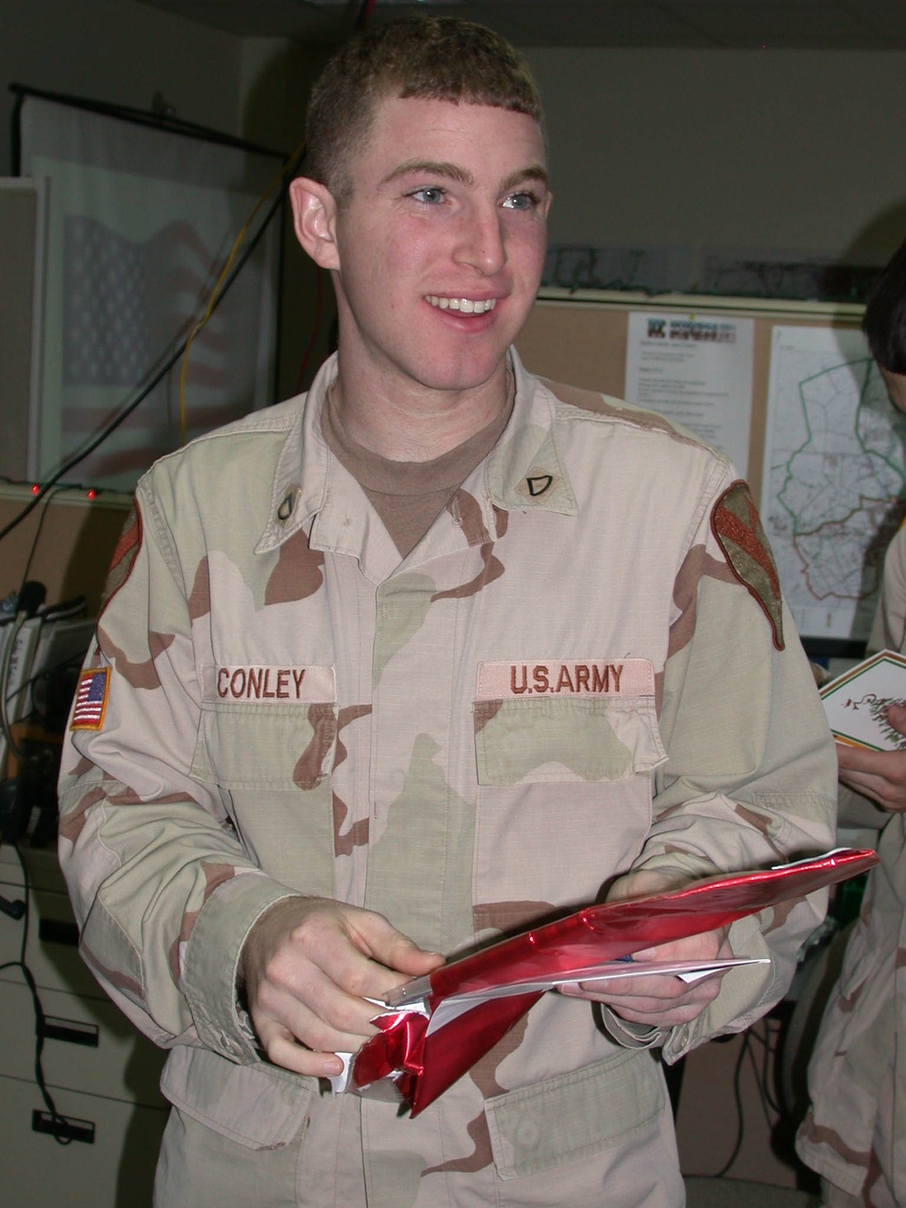 Pfc. Bart Conley opens a present on Christmas Day