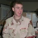 Pfc. Bart Conley opens a present on Christmas Day