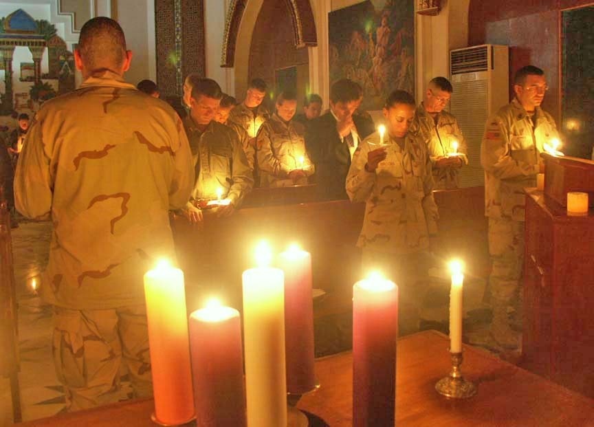 Soldiers bow their heads as the benediction is given