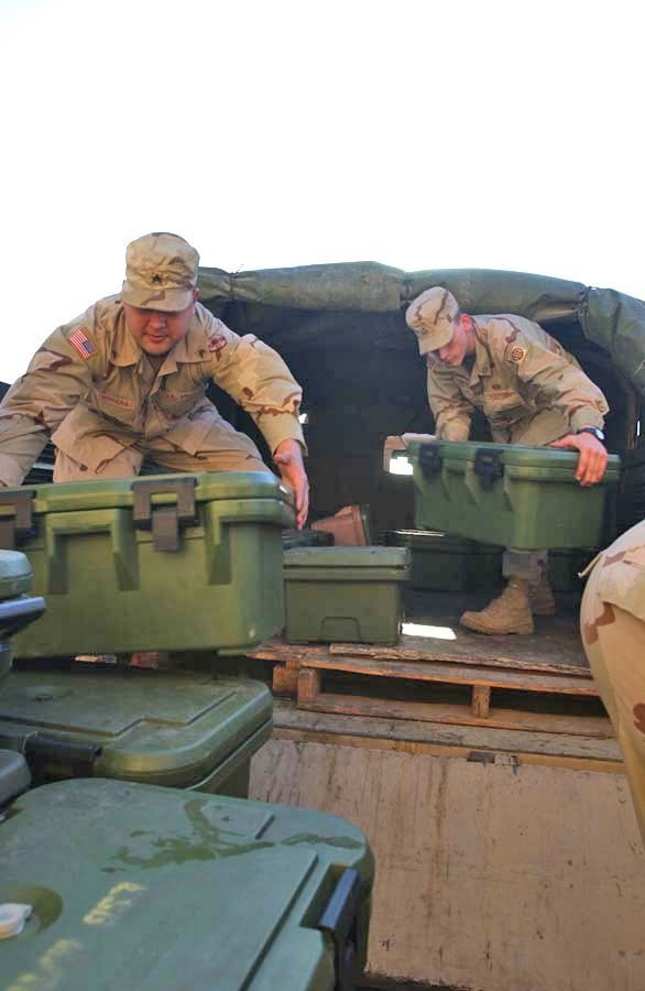 Pfc. Patrick Fenton helps unload empty food containers