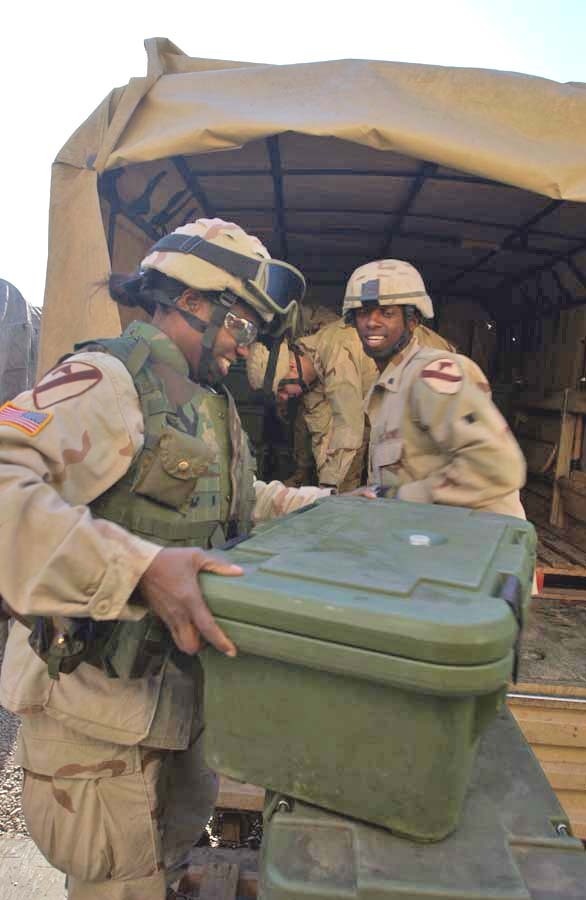 SGT Church helps load the lunch meal onto a truck with Spc. Char